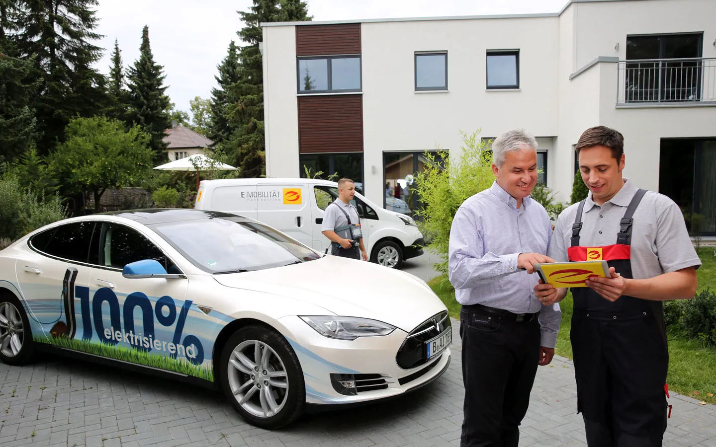 E-Mobilität - Mitarbeiter mit Kunden vor Elektrofahrzeugen 100% elektrisch &middot; Elektro Dörr